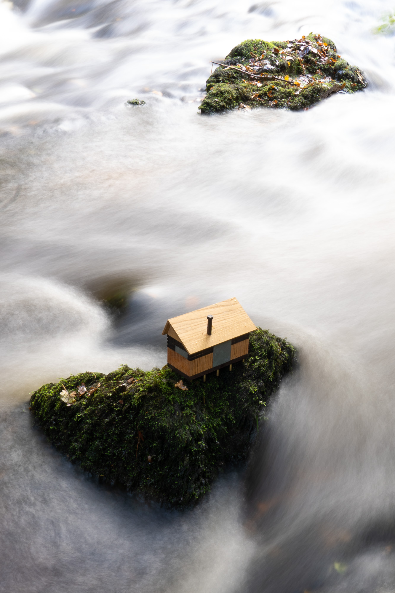 cabin model on a rock in a dartmoor river