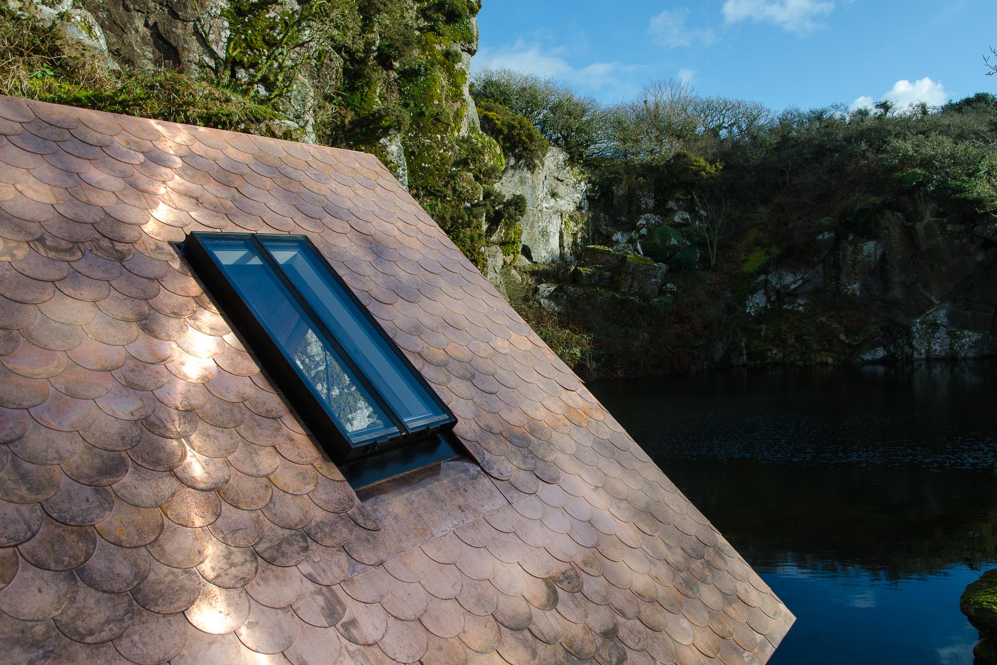 sauna cabin copper fish scale tiles overlooking quarry and water